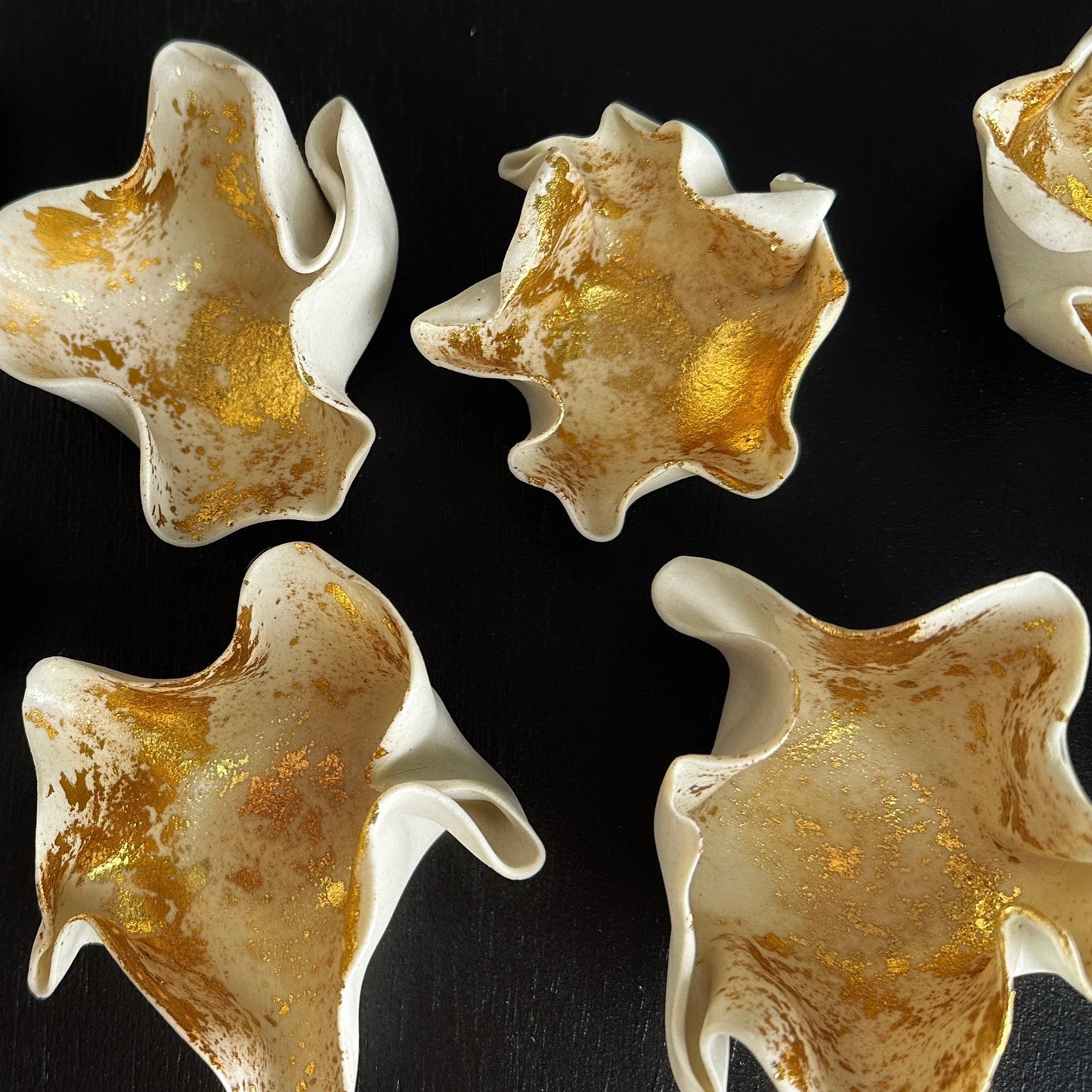 White and gold ceramic pieces on a black background