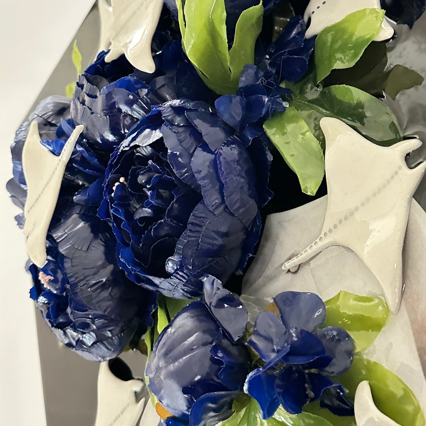 Bouquet of blue and white flowers with green leaves on a white background