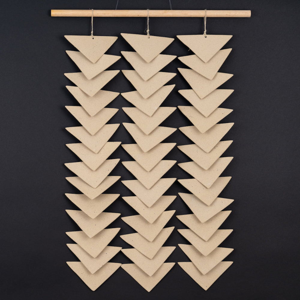 Sculptural ceramic wall panel featuring soft curves and a neutral glaze, ideal for contemporary spaces.